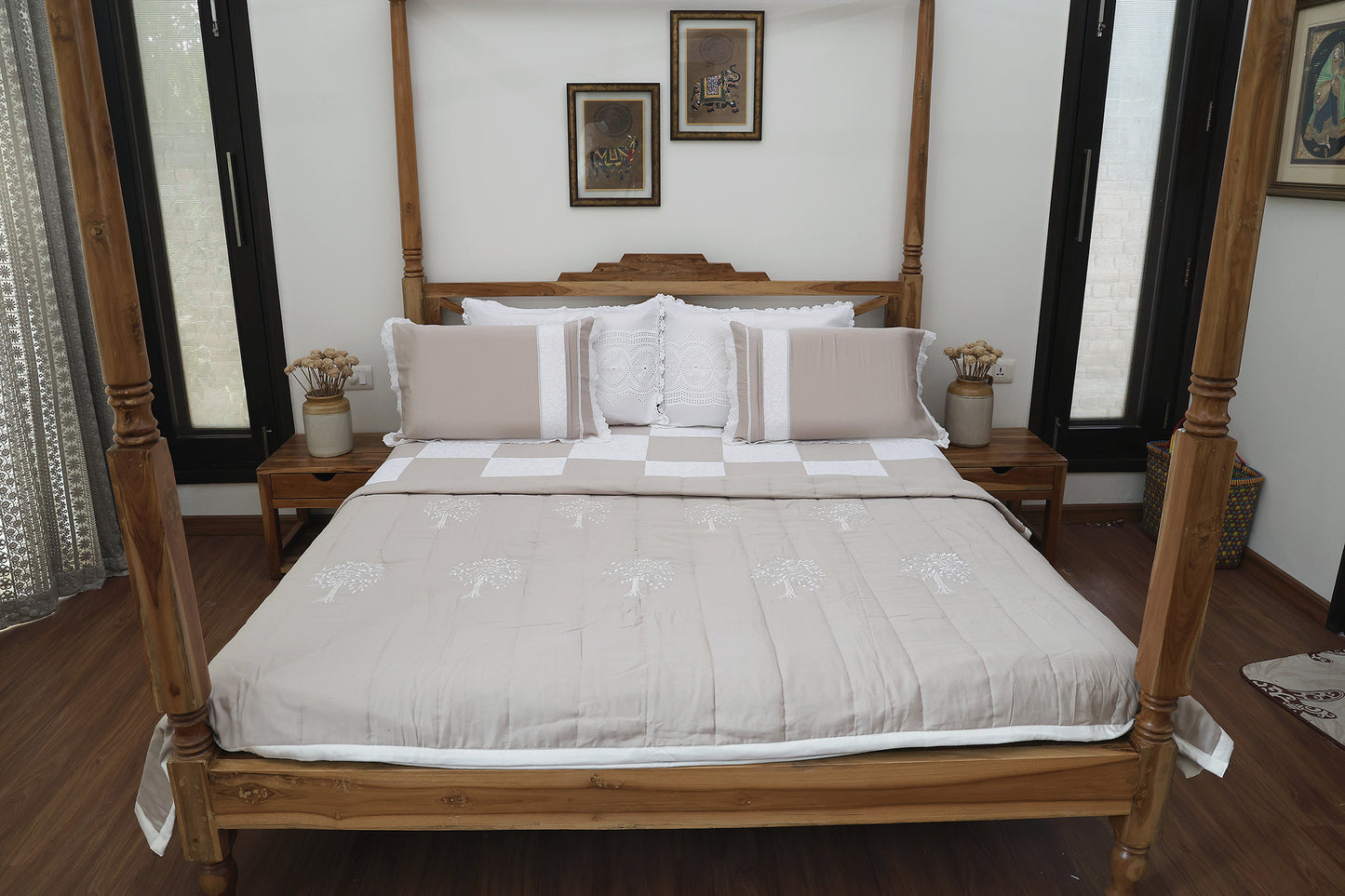 A beige and ivory patchwork bedsheet with Chikankari embroidery, displayed on a bed, accompanied by matching pillow covers and an AC quilt.